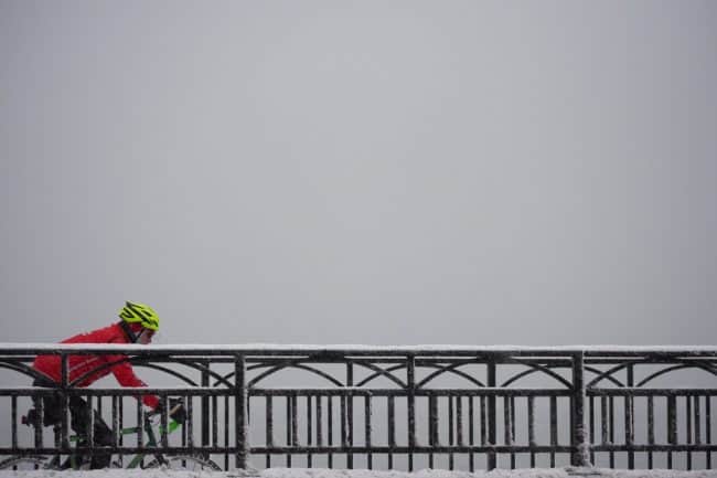 bicyclist riding in cold, snowy, winter weather