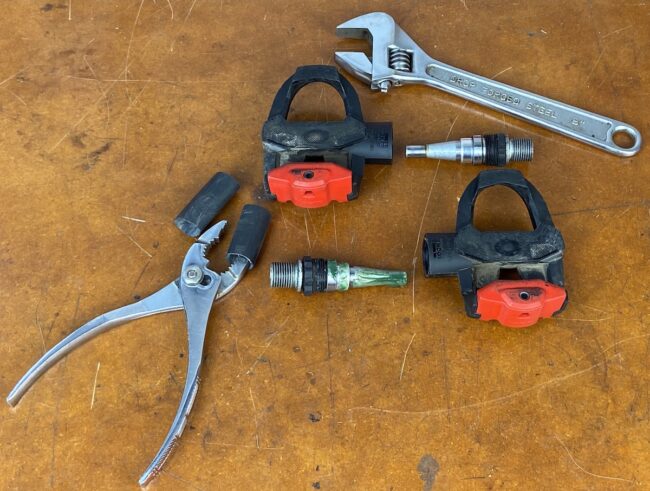 using adjustable wrench to disassemble Look pedals and remove spindles